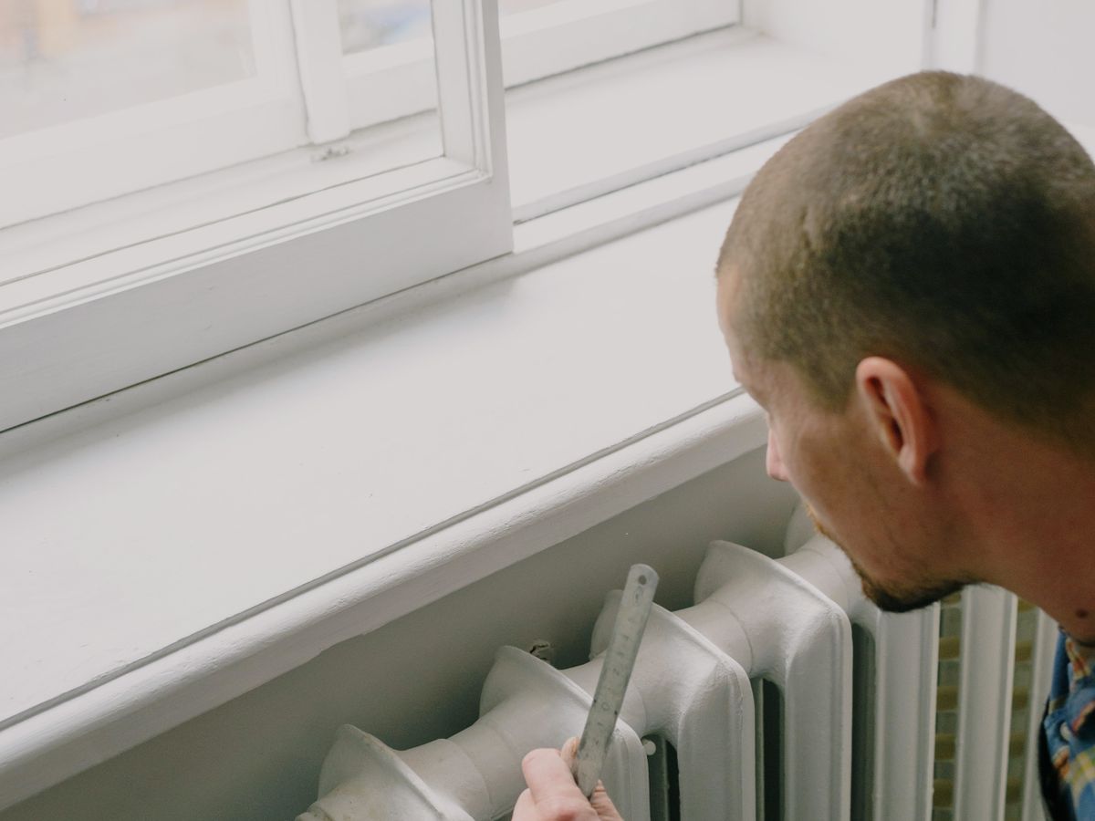 A heating engineer checking over a radiator